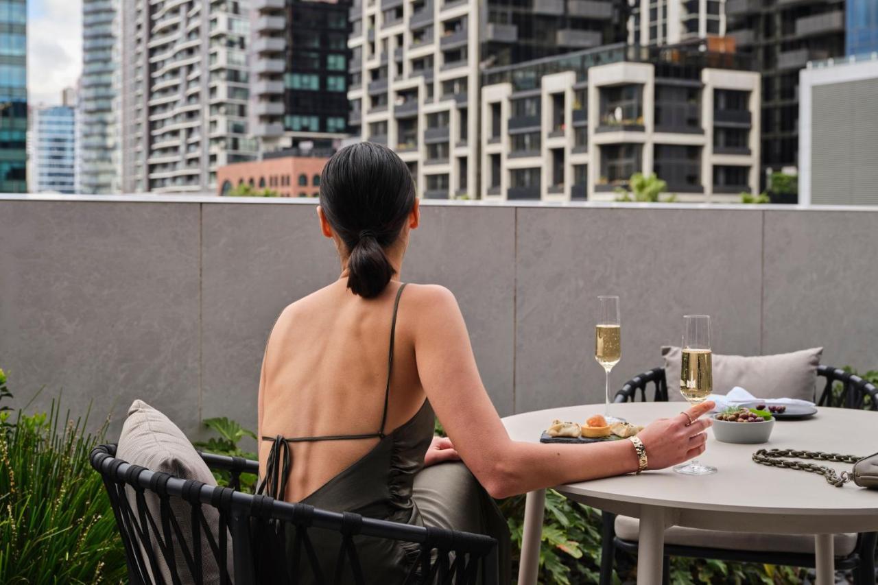Melbourne Marriott Hotel Docklands Exteriör bild A woman sitting on a balcony